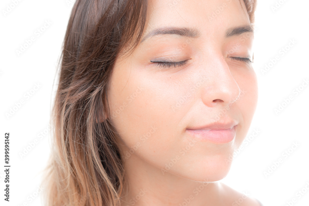 A young beautiful brunette with her eyes closed against white background A young beautiful brunette with her eyes closed against white background