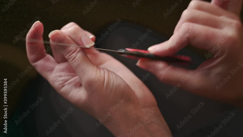 Nail treatment. A woman makes herself a manicure at home, sharpens her nails with a nail file, close-up of her hands. Nail treatment. A woman makes herself a manicure at home, sharpens her nails with a nail file, close-up of her hands.