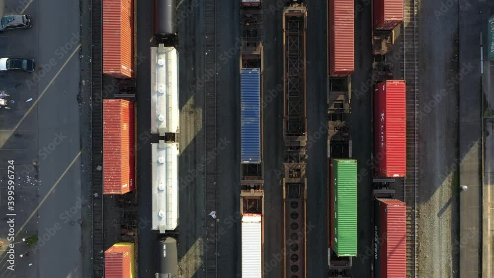 Drone footage of a rail yard, tracks with railroad cars, tankers and ...