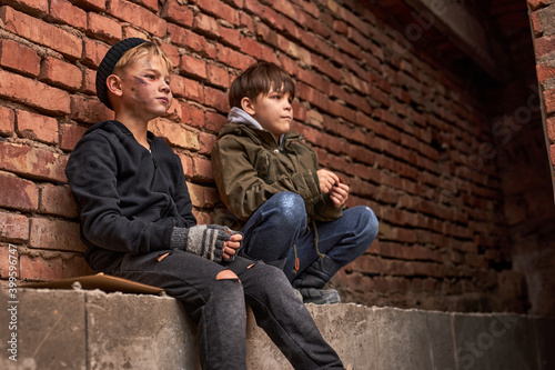 Slika na platnu two orphans children begging in town streets, it's cold outdoors, need shelter a