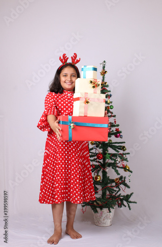 Cute little Indian girl holding Christmas gift.