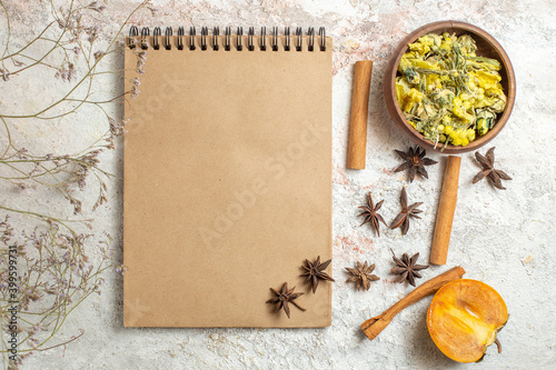 notebook and different herbs and half palm on marble background