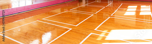 Horizontal view of dance room floor with white tape marked for social distancing