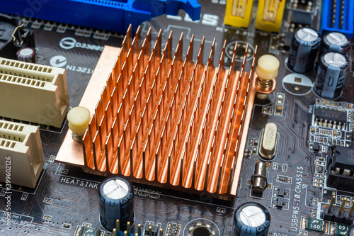 Close up view of copper heat sink or radiator on computer motherboard.