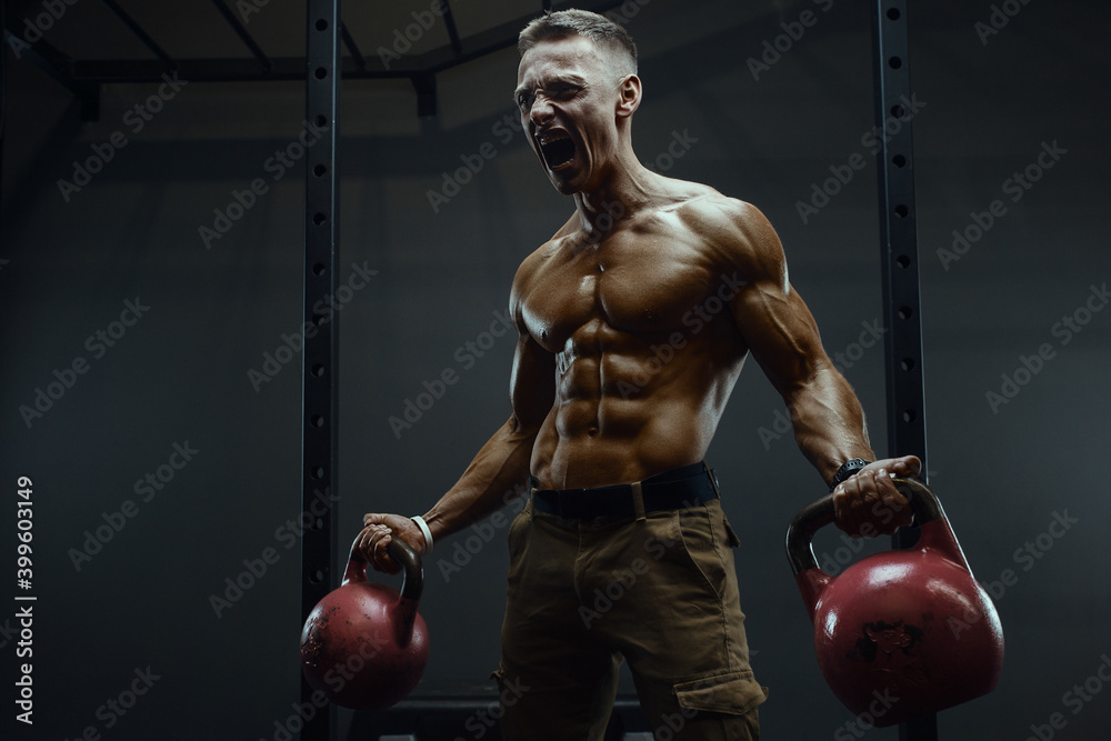 Fitness man pumping up muscles with kettlebell Fitness man pumping up muscles with kettlebell