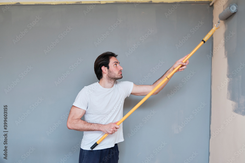 Young handsome man painting his walls Young handsome man painting his walls