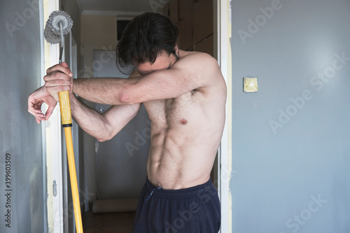 Shirtless attractive man painting his walls photo