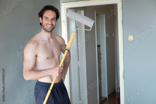 Shirtless attractive man painting his walls photo