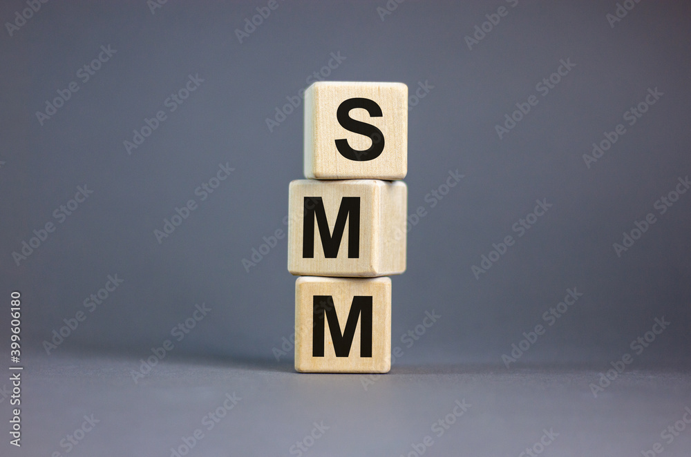 SMM symbol. Wooden cubes with word 'SMM - social media marketing' on beautiful grey background, copy space. Business and SMM concept. SMM symbol. Wooden cubes with word 'SMM - social media marketing' on beautiful grey background, copy space. Business and SMM concept.