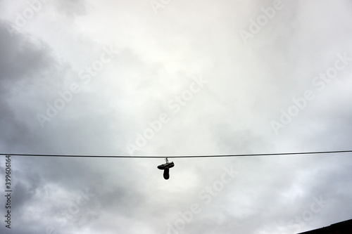 A cable with a pair of shoes hanging down from the wire