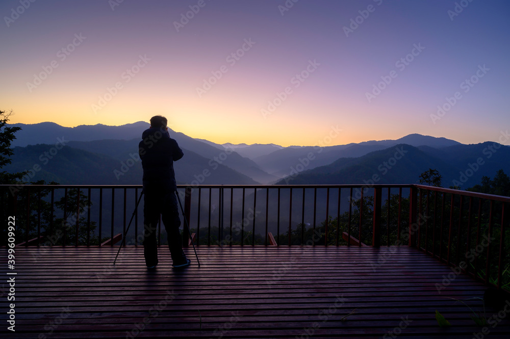 Asian tourists take pictures of the mountains and fog at the morning sunrise.