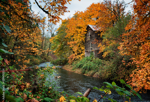 Fall colors along river with old flower mill