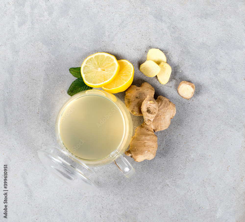 Drink tea lemon ginger with honey in a glass cup on a light gray background top view Drink tea lemon ginger with honey in a glass cup on a light gray background top view