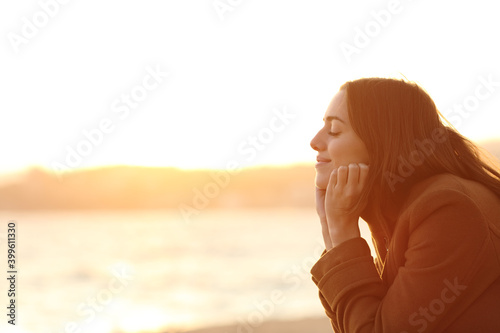 Woman at sunset relaxing mind on the beach in winter photo