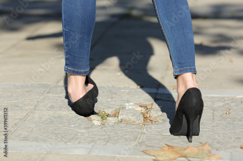 Foto Woman walking spraining ankle stumbling in the street