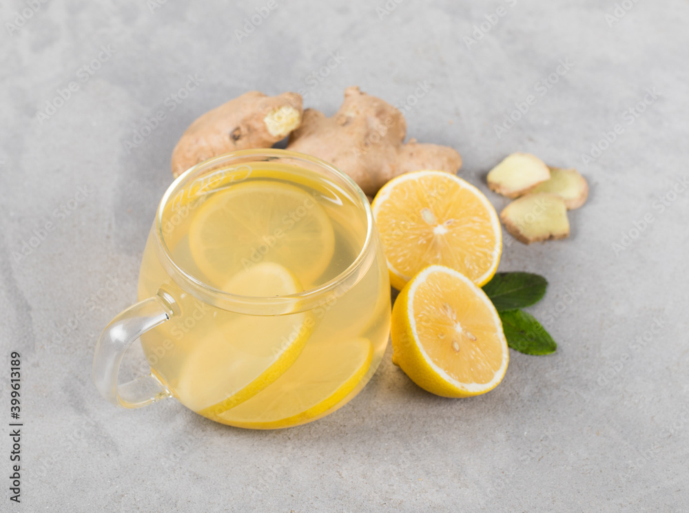 Tea lemon ginger in a glass cup on a light gray background Tea lemon ginger in a glass cup on a light gray background