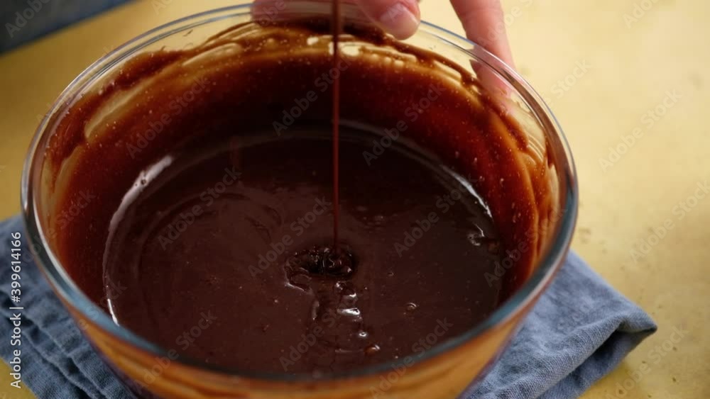 Close-up of female hands preparing the dough for a chocolate cake. Cooking brownies. Chocolate cream for a cake. Close-up of female hands preparing the dough for a chocolate cake. Cooking brownies. Chocolate cream for a cake.
