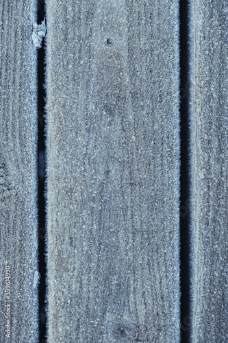 Background with wooden boards covered with snow and frost. Frost on the wooden surface, formed by fog under the influence of cold temperature. Top view. Copy, empty space for text