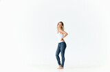 woman in full growth on a light background in jeans and a t-shirt model 