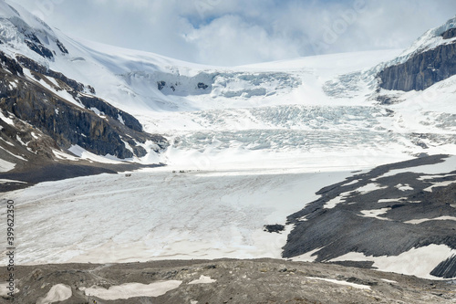 The Athabasca Glacier in the Columbia Icefield in Alberta, Canada. The scale can be seen middle left by the trucks and people on the glacier. photo