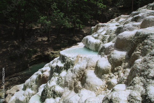 natural outdoor thermal spring free to the public in the woods, large limestone conformations from where hot water comes out photo