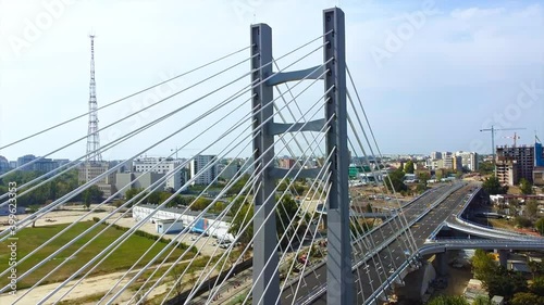 Ciurel passage, bridge over a river with moving cars, construction works, field and TV tower near it. Residential buildings on the background. View from the drone. Bucharest, Romania photo