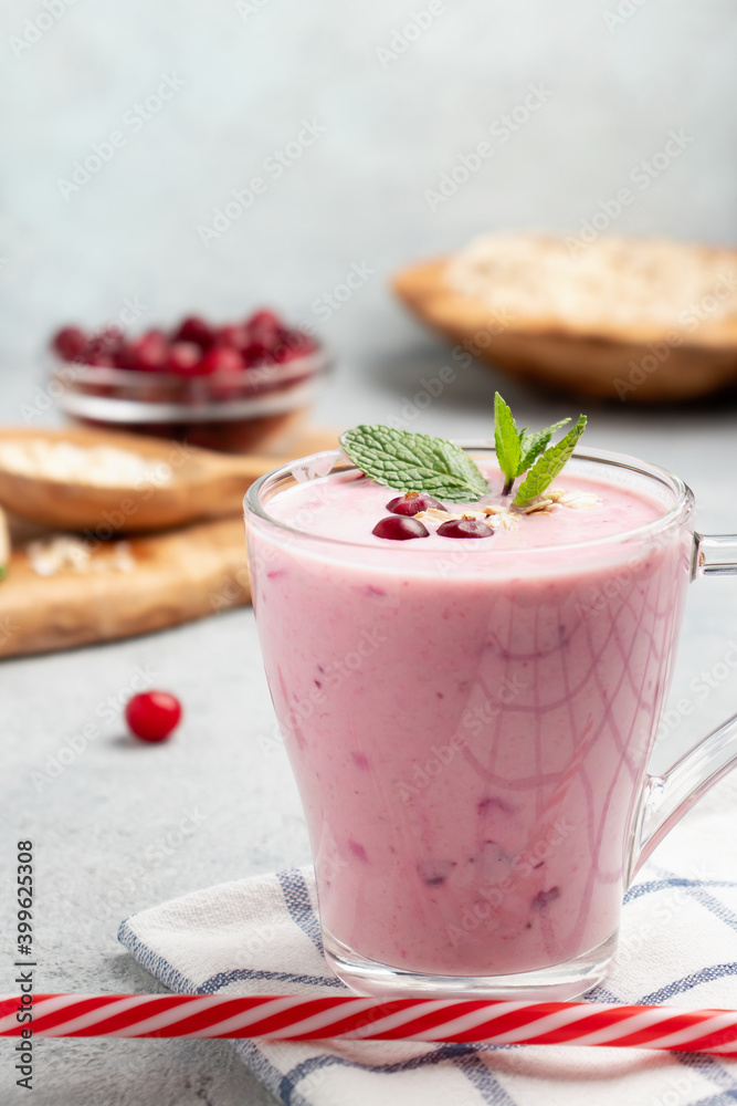 Homemade yogurt smoothie with banana, cranberry and oatmeal, copy space Homemade yogurt smoothie with banana, cranberry and oatmeal, copy space