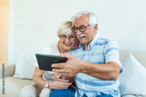 Cheerful senior people websurfing on internet with tablet,family, technology, age and people concept - happy senior couple with tablet pc computer at home
