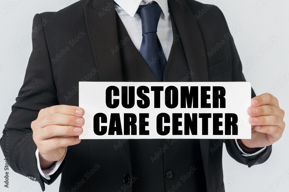 Obraz premium A businessman holds a sign in his hands which says - CUSTOMER CARE CENTER