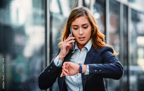 Something going wrong. Businesswoman on the way to office looking at watch while waiting money transfer. Business, lifestyle concept