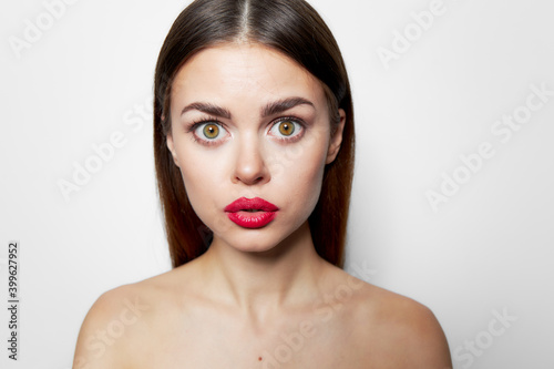 Woman with surprised facial expression red lips bared shoulders cropped 
