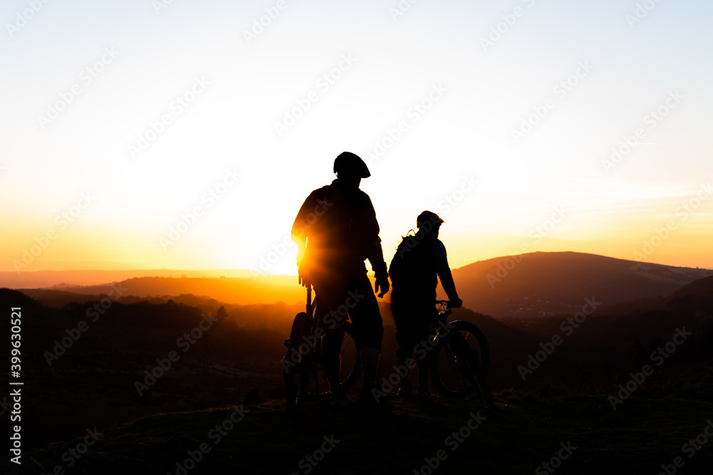 silhouette of a couple on a bike at sun set