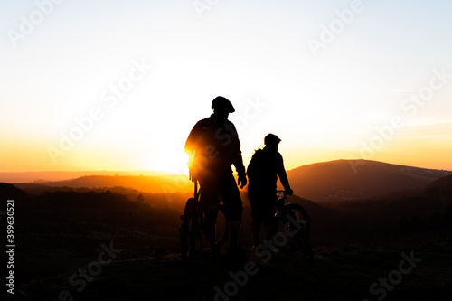 silhouette of a couple on a bike at sun set