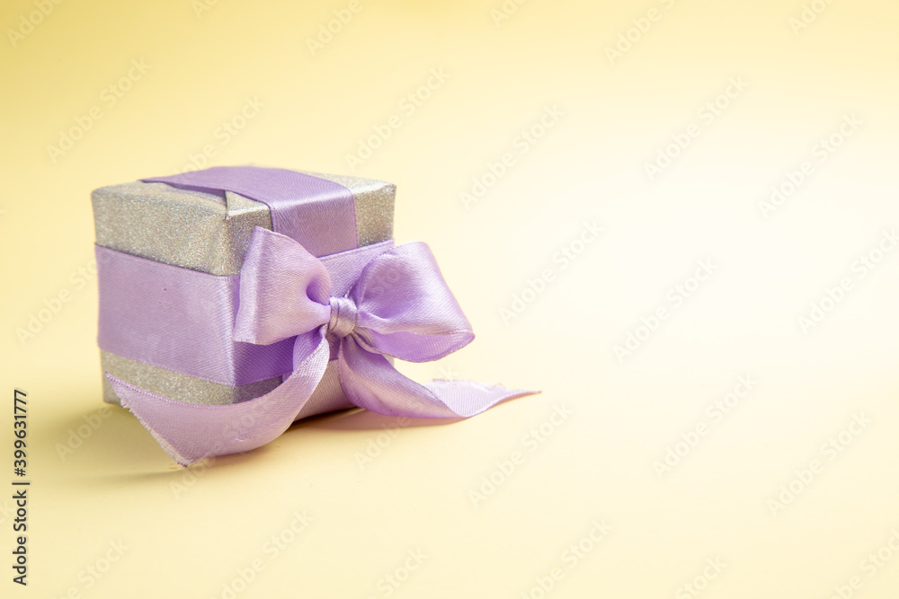front view little present on light-yellow background new year holiday xmas gift color photo free place front view little present on light-yellow background new year holiday xmas gift color photo free place