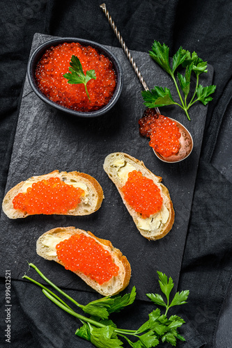 Sandwiches with salmon red caviar. Black background. Top view