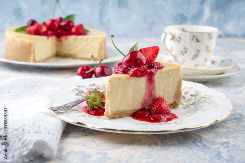 Traditional German cheesecake with cherry and strawberry fruits served as close-up on a classic design plate on a wooden table