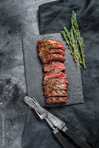 Grilled roasting rare sliced top blade, Denver steak. Marble meat beef. Black background. Top view