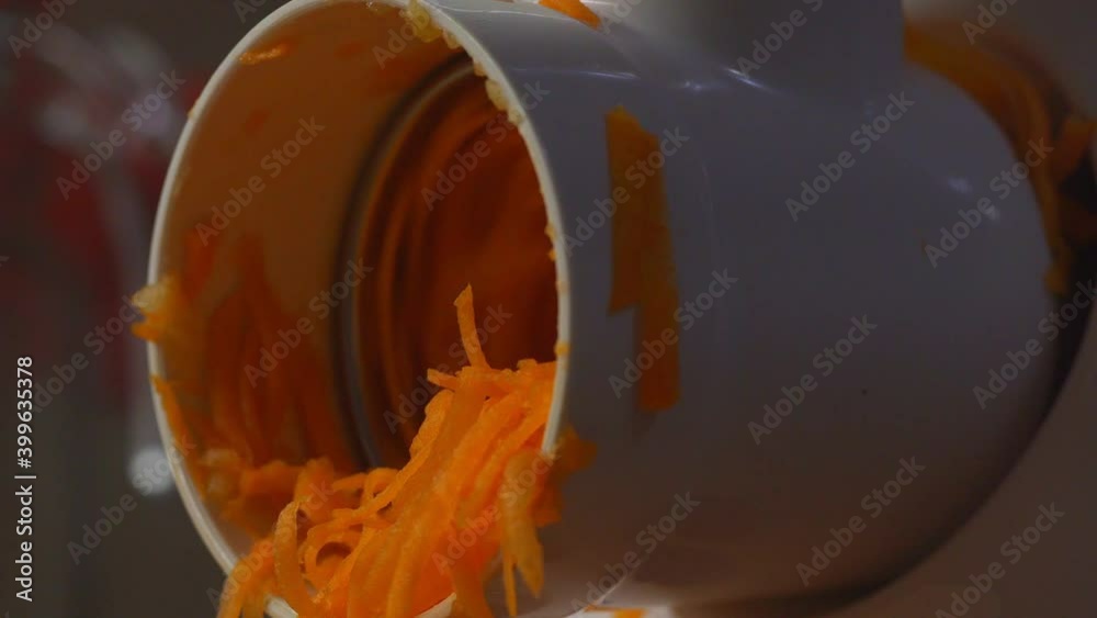 finely chop carrots for making salad in an electric meat grinder