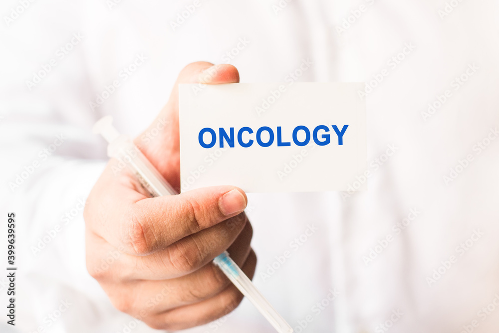Word oncology on a white background with a syringe in hand. Word oncology on a white background with a syringe in hand.