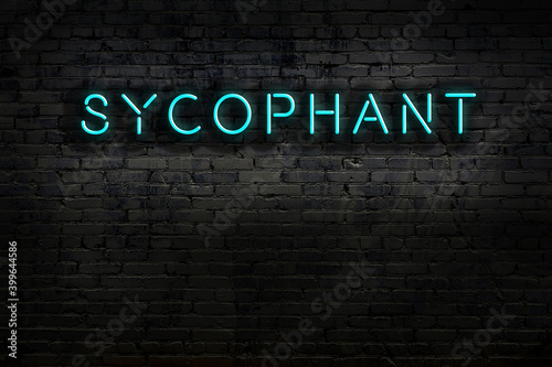Neon sign. Word sycophant against brick wall. Night view