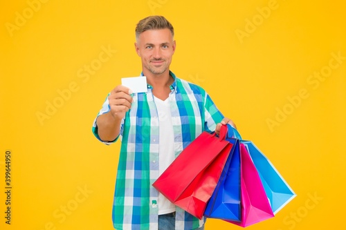 holiday flash sale and special offer. cyber monday in shop. customer. successful male shopping. man with paperbags show business or credit card. purchase in paper bags. guy hold gift. Clothing store