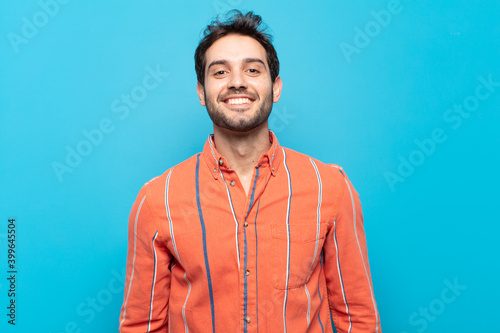 young handsome man looking happy and goofy with a broad, fun, loony smile and eyes wide open