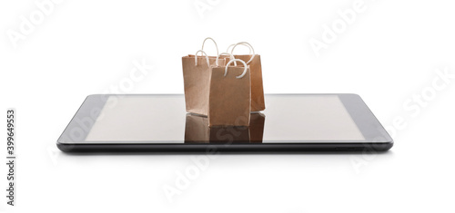 Internet shopping. Small paper bags and modern tablet on white background