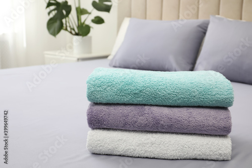 Stack of clean towels on bed indoors