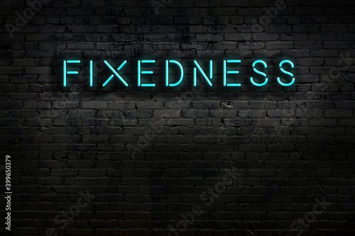 Neon sign. Word fixedness against brick wall. Night view photo