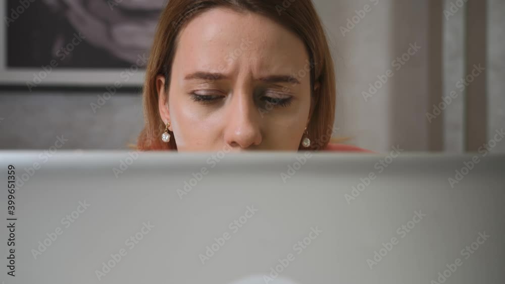 Close up worried sad businesswoman face looking at laptop at the home office. Close up of upset woman thinking about mistakes in work. Portrait of sad girl looking laptop. Depressed employee working Close up worried sad businesswoman face looking at laptop at the home office. Close up of upset woman thinking about mistakes in work. Portrait of sad girl looking laptop. Depressed employee working