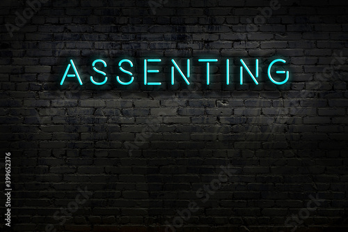 Foto Neon sign. Word assenting against brick wall. Night view