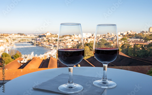 Tasting of different fortified dessert ruby, tawny port wines in glasses with view on Douro river, porto lodges of Vila Nova de Gaia and city of Porto, Portugal photo