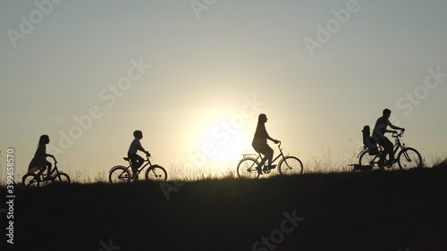 A friendly large family with bicycles at sunset.
