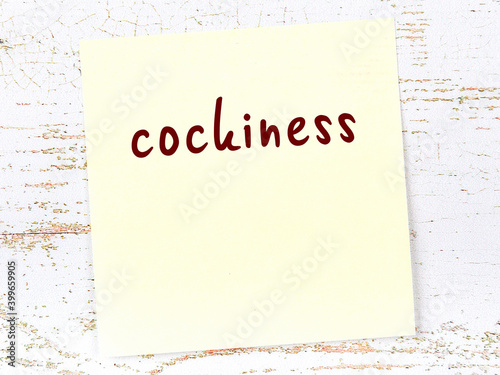 Yellow sheet of paper with word cockiness. Reminder concept photo